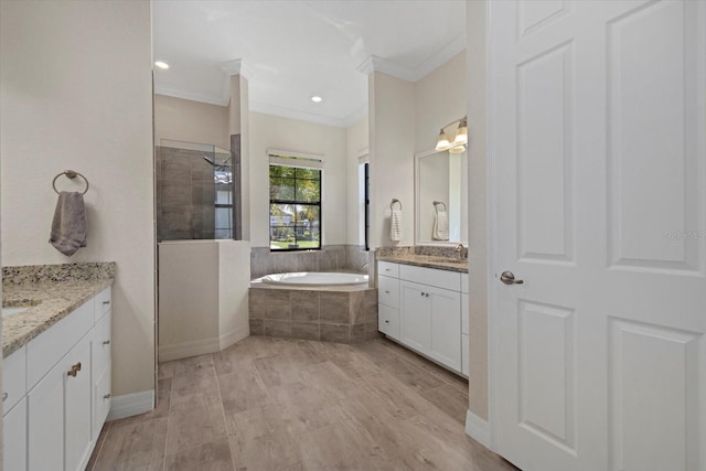 full bathroom featuring a sink, a walk in shower, a garden tub, and ornamental molding