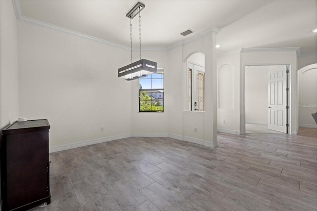 unfurnished dining area featuring visible vents, arched walkways, baseboards, and crown molding