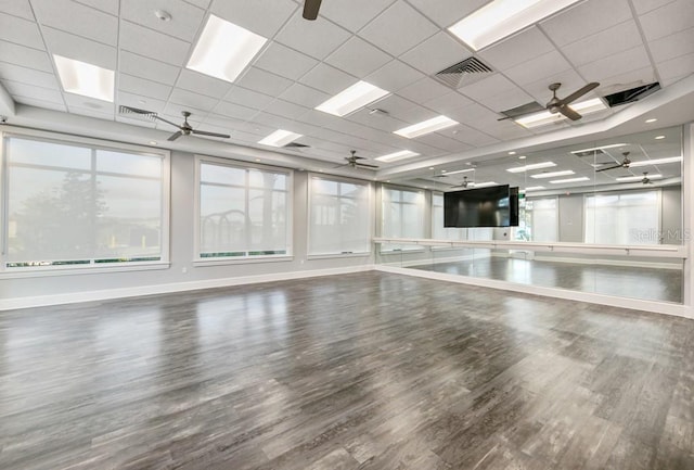 interior space with ceiling fan, visible vents, baseboards, and wood finished floors