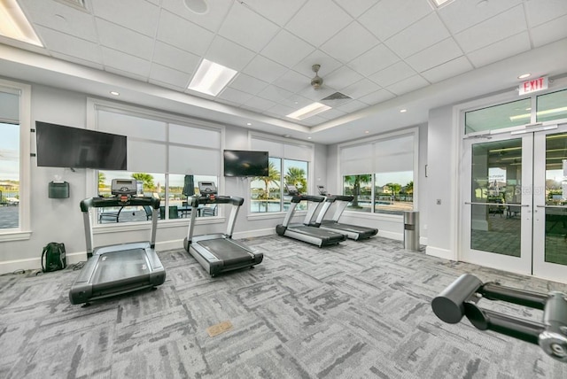 exercise room featuring a drop ceiling, visible vents, baseboards, and carpet floors