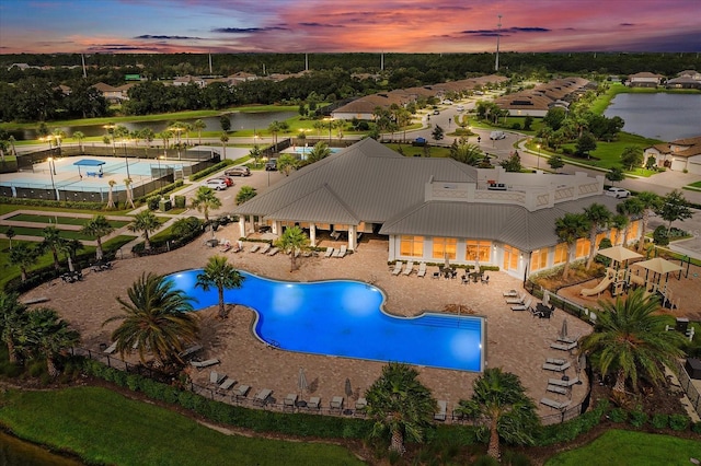 view of swimming pool featuring a water view, fence, and a patio area