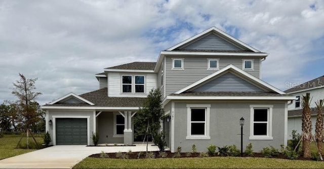 view of front of home with stucco siding, concrete driveway, and an attached garage