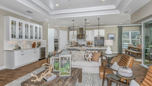 living room with visible vents, dark wood-type flooring, a tray ceiling, wine cooler, and baseboards