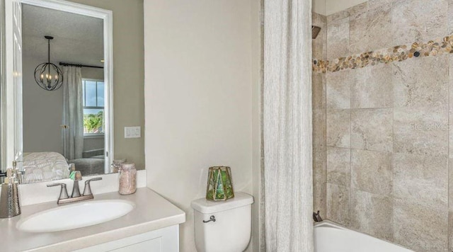 bathroom featuring toilet, vanity, shower / bath combo with shower curtain, a notable chandelier, and ensuite bath