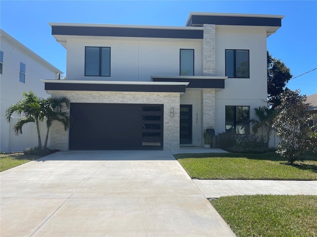 modern home featuring a front yard, stucco siding, a garage, stone siding, and driveway