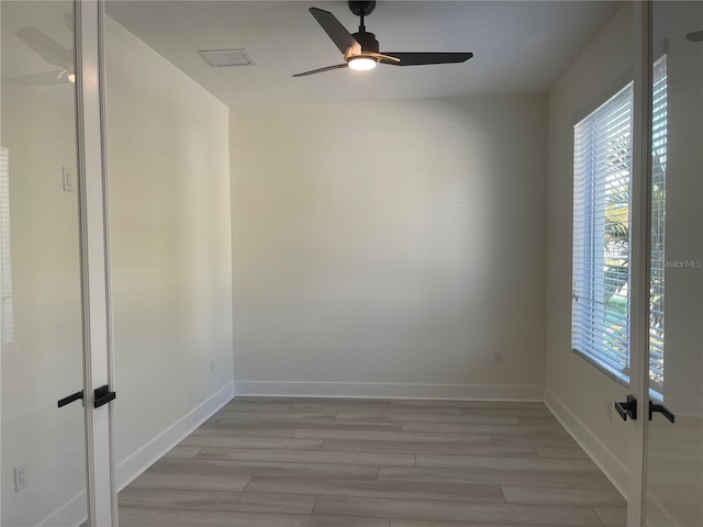 unfurnished room with visible vents, light wood finished floors, and ceiling fan