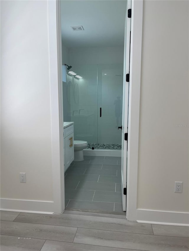 bathroom with vanity, baseboards, visible vents, and a stall shower