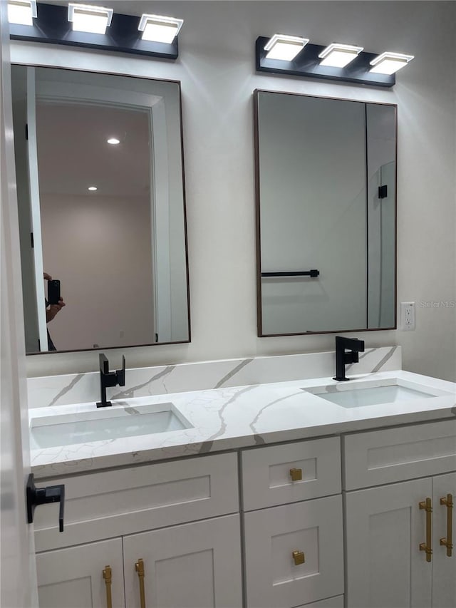 bathroom featuring a sink and double vanity