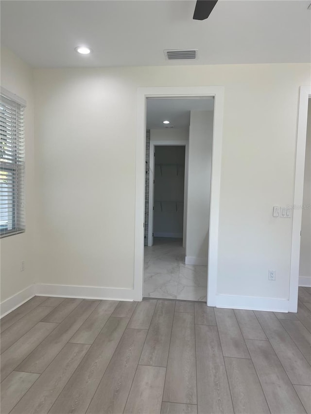 spare room with visible vents, recessed lighting, baseboards, and wood finished floors