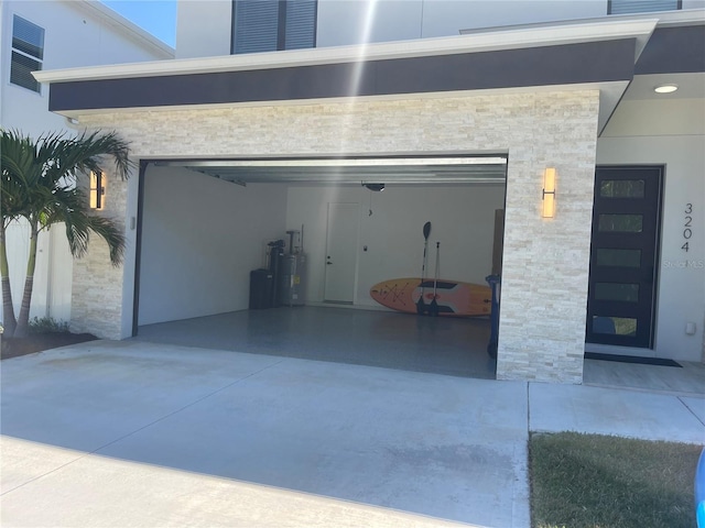 garage featuring water heater and driveway