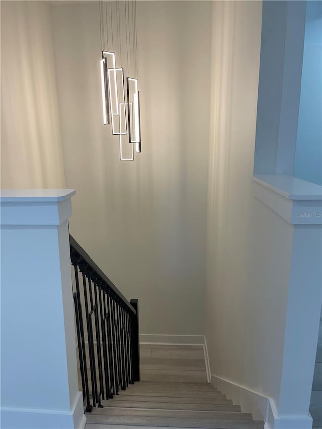 stairway featuring wood finished floors and baseboards