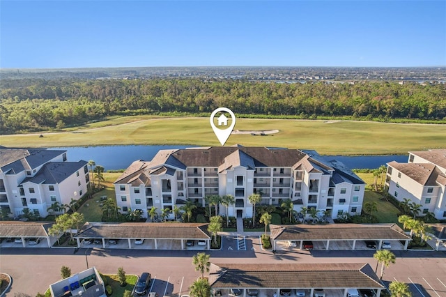 drone / aerial view with a water view and golf course view