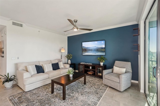 living area featuring visible vents, ornamental molding, a ceiling fan, light tile patterned flooring, and baseboards