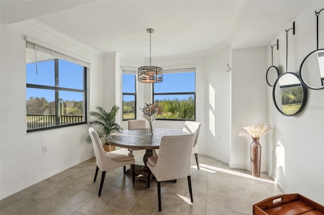 dining space featuring tile patterned flooring, ornamental molding, baseboards, and a chandelier