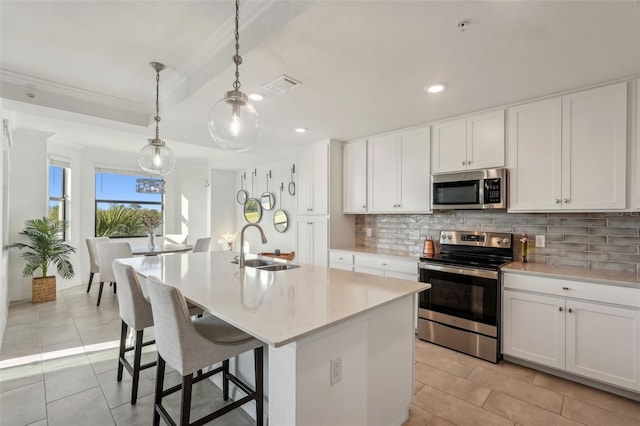 kitchen featuring visible vents, light tile patterned floors, decorative backsplash, stainless steel appliances, and a sink