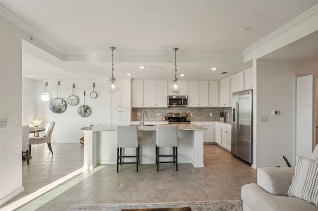 kitchen with a breakfast bar, ornamental molding, a sink, tasteful backsplash, and stainless steel appliances