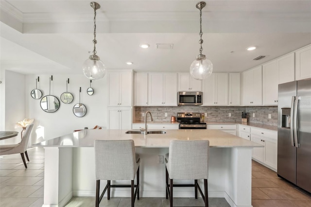 kitchen with visible vents, decorative light fixtures, decorative backsplash, appliances with stainless steel finishes, and a sink