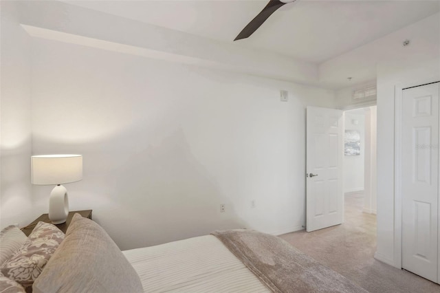 bedroom featuring light carpet, baseboards, and a ceiling fan