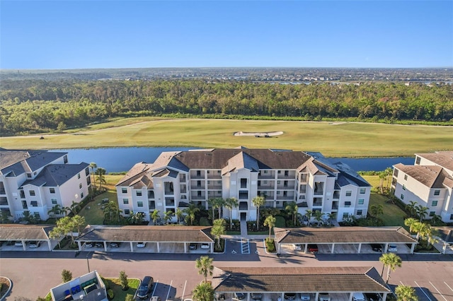 drone / aerial view with a water view and view of golf course