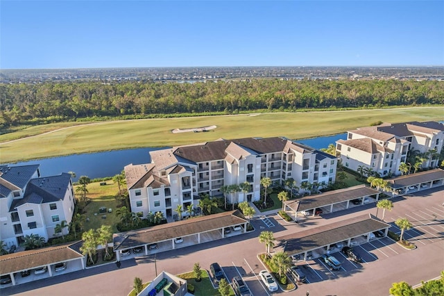 birds eye view of property with view of golf course and a water view