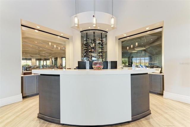 bar with light wood finished floors, recessed lighting, pendant lighting, and baseboards