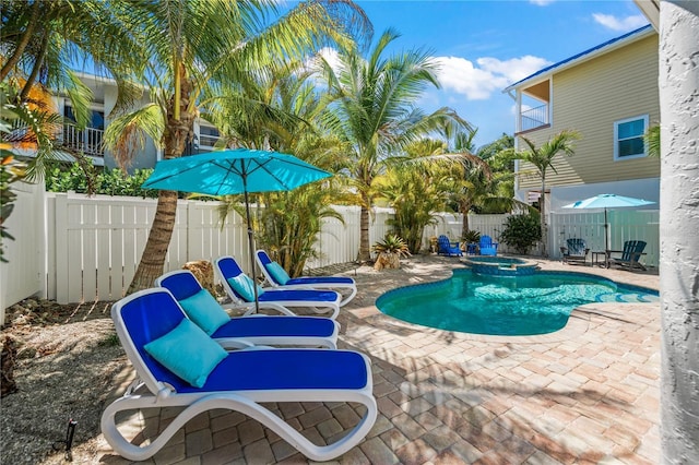 view of swimming pool with a pool with connected hot tub, a patio, and a fenced backyard