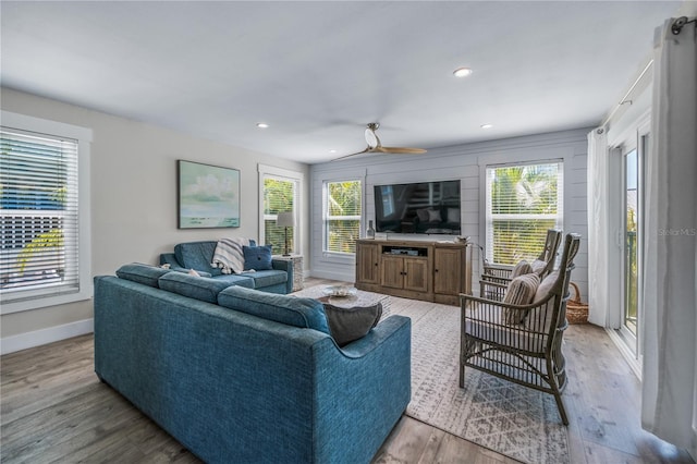 living room with recessed lighting, baseboards, wood finished floors, and a healthy amount of sunlight