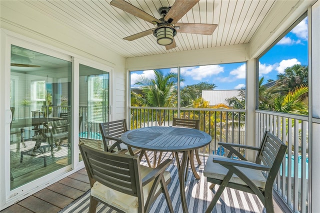 sunroom with a ceiling fan and outdoor dining space