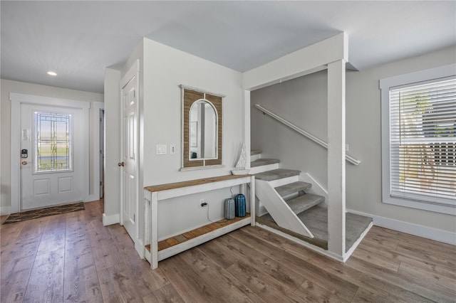 foyer featuring recessed lighting, stairs, wood finished floors, and baseboards