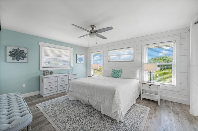 bedroom featuring a ceiling fan, wood finished floors, and baseboards