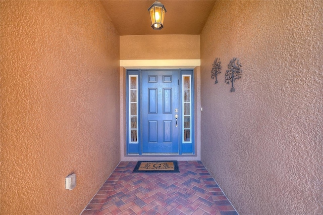 entrance to property featuring stucco siding