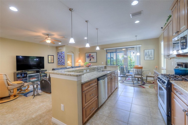 kitchen featuring visible vents, a sink, open floor plan, appliances with stainless steel finishes, and ceiling fan