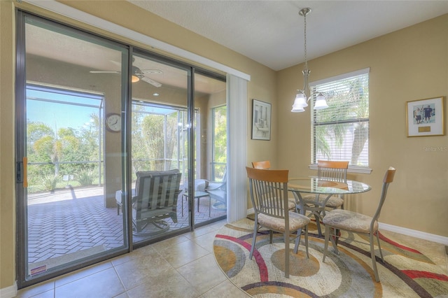 tiled dining room featuring baseboards and ceiling fan