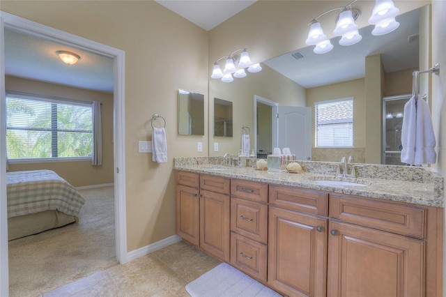 full bath featuring tile patterned floors, double vanity, baseboards, and a sink