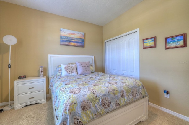 bedroom with light colored carpet, a closet, and baseboards