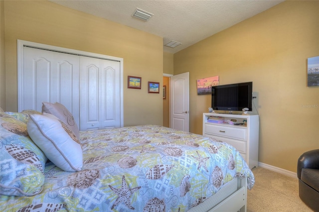 bedroom featuring baseboards, visible vents, a closet, a textured ceiling, and light carpet