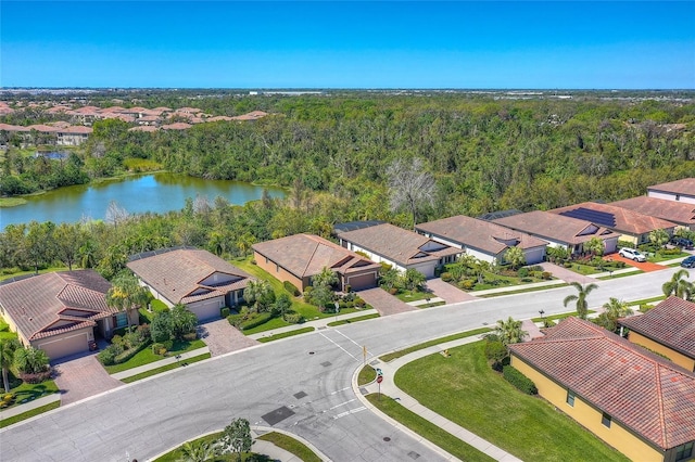 drone / aerial view with a view of trees, a residential view, and a water view