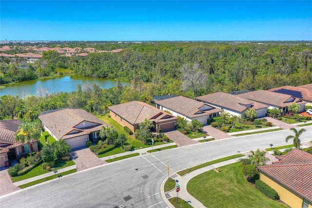 birds eye view of property featuring a residential view, a forest view, and a water view