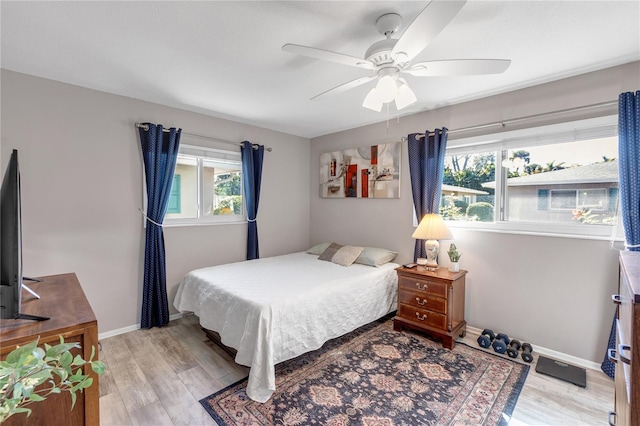 bedroom featuring baseboards, light wood-type flooring, and ceiling fan