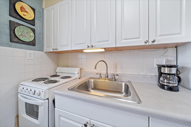 kitchen featuring a sink, white cabinets, and white electric range oven