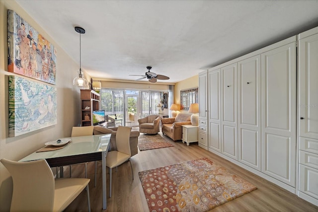 dining area featuring light wood-style flooring and a ceiling fan