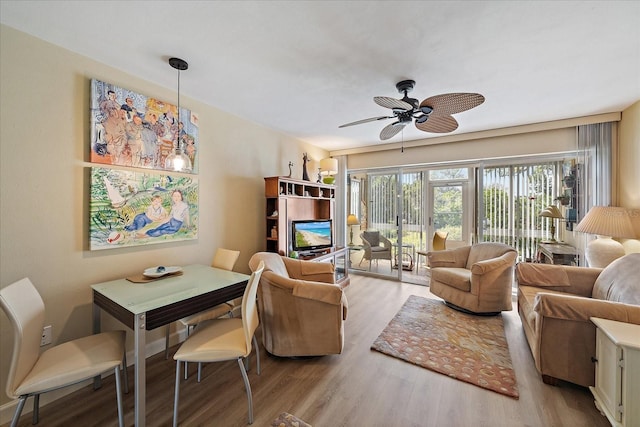 living area with wood finished floors and a ceiling fan