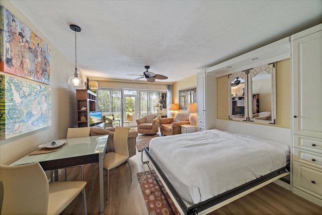 bedroom featuring a ceiling fan, access to outside, and wood finished floors