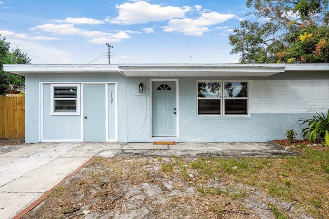 view of front of home featuring fence and stucco siding