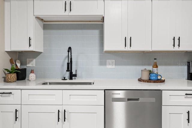 kitchen with a sink, white cabinets, light countertops, decorative backsplash, and dishwasher