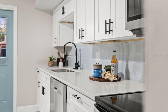 bar featuring a sink, stainless steel dishwasher, black / electric stove, decorative backsplash, and baseboards