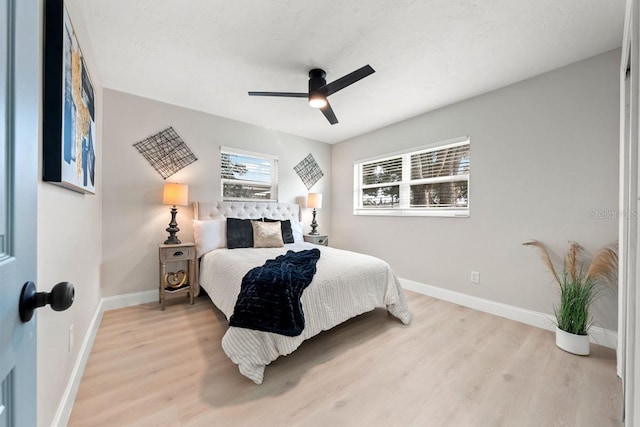 bedroom with light wood-type flooring, baseboards, and a ceiling fan