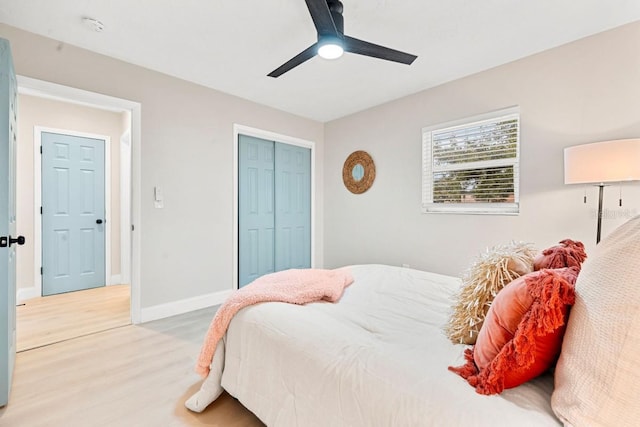 bedroom featuring ceiling fan, a closet, baseboards, and light wood-style flooring