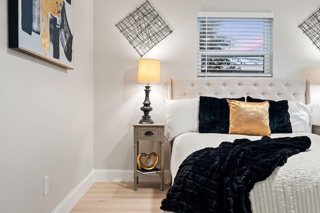 bedroom with baseboards and wood finished floors