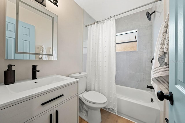 bathroom with vanity, toilet, wood finished floors, and shower / bath combo